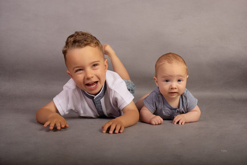 Dos hermanos jugando en el suelo